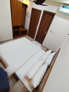 a bed with white sheets and wooden cabinets in a room at Handhuveli Dhangethi in Dhangethi