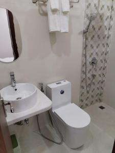 a bathroom with a toilet and a sink and a shower at Handhuveli Dhangethi in Dhangethi