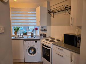 een keuken met een wasmachine en een magnetron bij Marina Place in Ramsgate +16 foto's