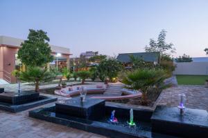 Un patio con una fuente y un edificio. en Private Home Gardens & Pools, Complementary tours and experiences inclusive, en Murayjāt