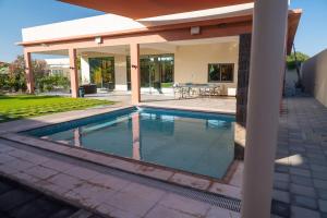 una piscina frente a una casa en Private Home Gardens & Pools, Complementary tours and experiences inclusive, en Murayjāt