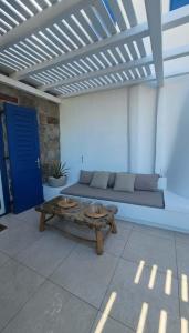 a living room with a couch and a table at Idyllic Mykonos Suite w Jacuzzi and Sea Panorama in Houlakia