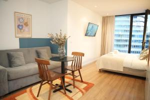 a living room with a couch and a table and chairs at Rooftop Tirana in Tirana