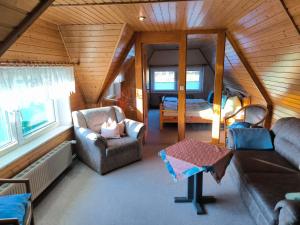 a living room with a couch and chair in a room at Schwanensee Ferienhaus in Göhren