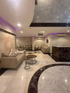 ein großes Wohnzimmer mit Sofas und einem Kamin in der Unterkunft فندق اوتاد البدر الششه in Al Khansāk