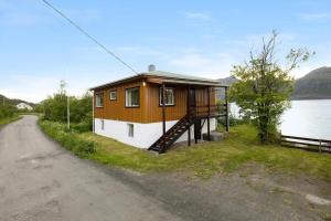 a house on the side of a road next to a lake at Room with Midnight-sun and Norhern-light View in Vestvågøya