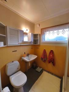 a bathroom with a white toilet and a sink at Room with Midnight-sun and Norhern-light View in Vestvågøya