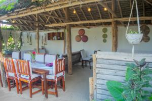 une salle à manger avec une table et des chaises dans l'établissement Mudi House, à Jambiani