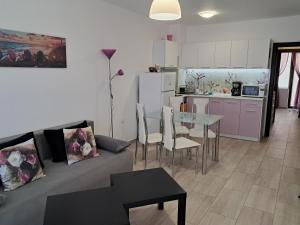 a living room with a couch and a table and a kitchen at Apart Hotel Iglika in Pomorie +24 photos