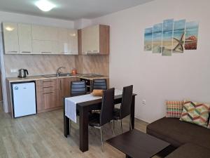 a kitchen and living room with a table and a couch at Apart Hotel Iglika in Pomorie