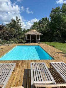 a swimming pool with two benches and a gazebo at Holiday Home With Outdoor Pool, Great Location in Hornsved