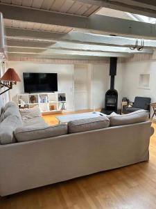 a large couch in a living room with a flat screen tv at Holiday Home With Outdoor Pool, Great Location in Hornsved +5 photos