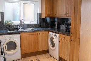 eine Küche mit Waschmaschine und Spüle in der Unterkunft La Casa de Class - Luxury & Comfort in Cardiff