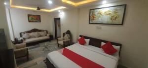 a room with a bed and a living room with a couch at New Shanti Hotel in Prayagraj +7 photos