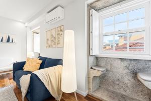 GuestReady - Charming Porto Retreat Near the Sea في بورتو: غرفة معيشة مع أريكة زرقاء ونافذة