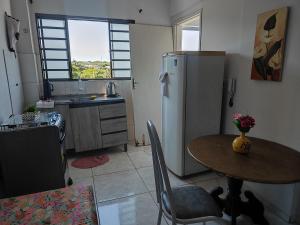 a kitchen with a table and a refrigerator at Apartamento Larah in Cianorte