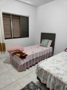 a bedroom with two beds and a window at Apartamento Larah in Cianorte