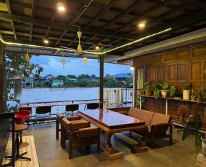 a dining room with a table and a view of the water at Baan Keang Chon Ayutthaya บ้านเคียงชล อยุธยา in Phra Nakhon Si Ayutthaya