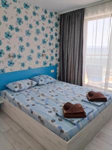 a bedroom with a blue bed with a blue headboard at Apart Hotel Iglika in Pomorie