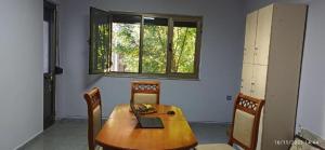 a dining room with a wooden table with a laptop on it at ROYAL Hostel in Tirana