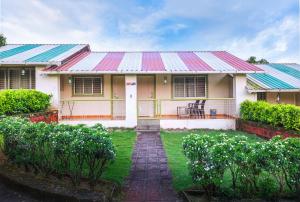 a house with a metal roof and a yard at Kokanwadi Resort in Ratnagiri