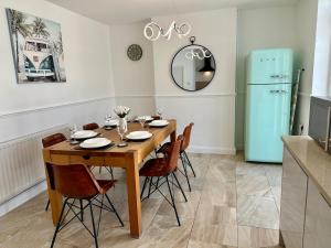 a dining room table with chairs and a blue refrigerator at 4 Bedroom House, En-Suite, 3 Doubles 1 Single, 2 Car Parking in Colchester