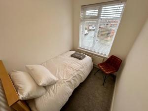 a small bedroom with a bed and a window at 4 Bedroom House, En-Suite, 3 Doubles 1 Single, 2 Car Parking in Colchester