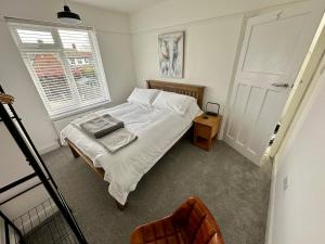 a bedroom with a white bed and a window at 4 Bedroom House, En-Suite, 3 Doubles 1 Single, 2 Car Parking in Colchester