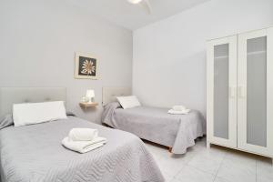 a bedroom with two beds with towels on them at Apto B-A almoraide suites in Nerja +23 photos
