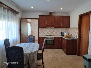 een keuken met een tafel en stoelen in een kamer bij Casa Tio Mário in Fontinhas +13 foto's