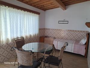 een kamer met een tafel en stoelen en een bed bij Casa Tio Mário in Fontinhas