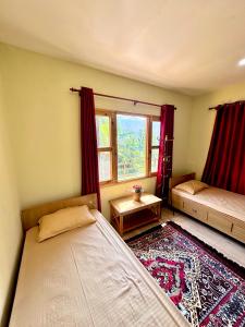 a bedroom with two beds and a window at Baloo's Family homestay in Pokhara