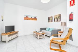 a living room with a couch and a tv at Apto B-A almoraide suites in Nerja