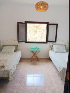 a room with two beds and a table in it at casa La cabaña Villa Palomino in Gáldar
