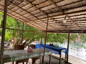 a table under a wooden pergola with a blue table at Mantorom homestay in Yennanas Besir