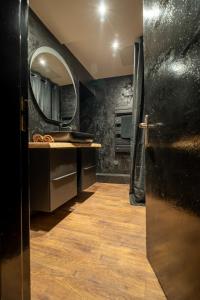 ein Badezimmer mit Waschbecken und Spiegel in der Unterkunft Le Confidentiel - Le Refuge de vos Désirs secrets in Sélestat