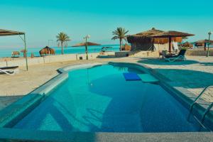 a swimming pool in front of the beach at Safari Beach Nuweiba in Nuweiba