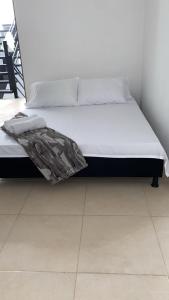 a bed in a room with white sheets and pillows at Casa HOTEL campestre TranKilandia in Rivera