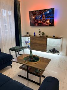 La Luna Premium Deluxe Apartment with Pool & Jacuzzi, Bikes and Covered Parking في Našice: غرفة معيشة مع شجرة عيد الميلاد على طاولة