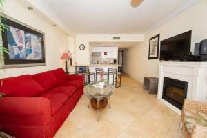 ein Wohnzimmer mit einem roten Sofa und einem Kamin in der Unterkunft Meridian Plaza 1002 in Myrtle Beach