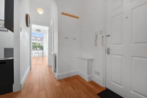 a kitchen with white walls and a wooden floor at WhiskAwayHomes - St Stephens Court - Apartment 2 in Henwick +22 photos