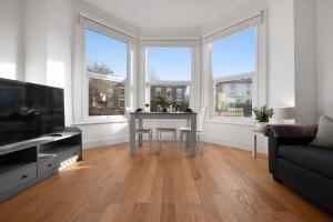 a living room with a table and some windows at WhiskAwayHomes - St Stephens Court - Apartment 2 in Henwick