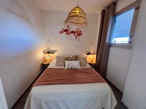 a bedroom with a bed and a chandelier at Magnifique T2 au calme avec une superbe vue sur le port in Canet-en-Roussillon
