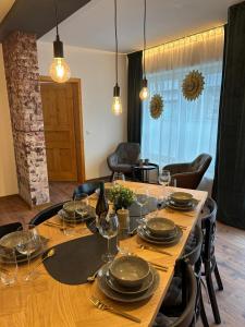 a wooden table with wine glasses and plates on it at Ferienwohnung Strizi in Ruhpolding