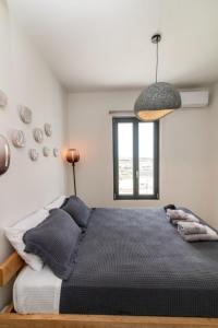 a bedroom with a bed and a window at Rockaine Suites Sunset in Agios Fokas +8 photos