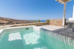 a swimming pool with a view of the ocean at Rockaine Suites Sunset in Agios Fokas