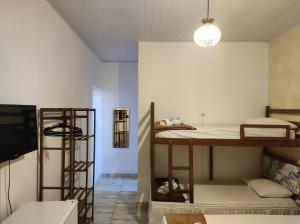 a room with two bunk beds and a flat screen tv at Hostel Vista Mar in Porto Seguro