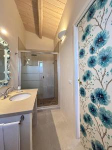 AlbaRosa في باكينو: حمام مع حوض ودش مع زهور زرقاء على الحائط