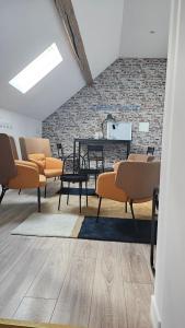 a room with chairs and a table and a brick wall at Chambre Cheverny, Casa 103 in Messas