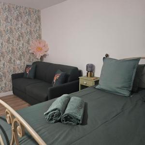 a bedroom with a bed with a couch at Chambre Cheverny, Casa 103 in Messas +9 photos